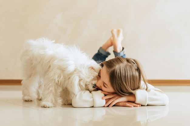 ragazza di 9 anni con capelli lunghi modello con un cane Studentessa maltese a casa stile di vita