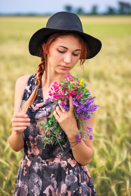 Ragazza di bellezza all'aperto che gode della natura. Bellissima modella adolescente ragazza in abito sul campo di primavera