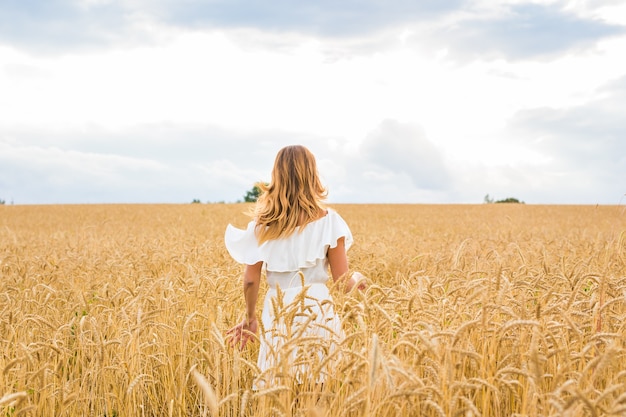 Ragazza di bellezza all'aperto godendo la natura sul campo.