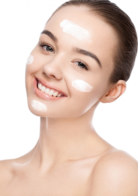 Ragazza di bellezza con crema per il viso