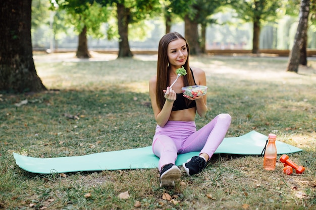 Ragazza di forma fisica che mangia sano nel parco