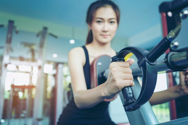 Ragazza di forma fisica che si esercita con il bilanciere in palestra.