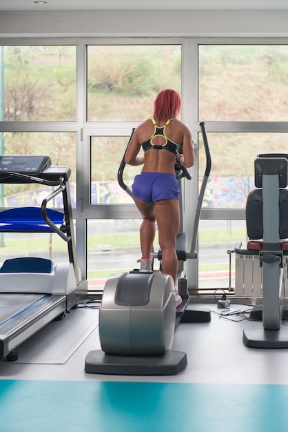 Ragazza di forma fisica che si esercita sul tapis roulant Moonwalker in un moderno centro fitness