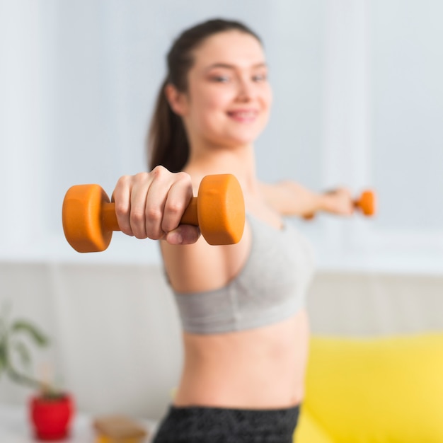 Ragazza di forma fisica che usando i dumbbells