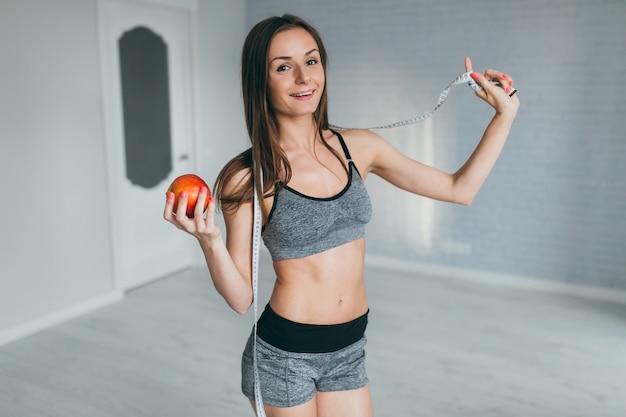 Ragazza di forma fisica usando un mesure del nastro