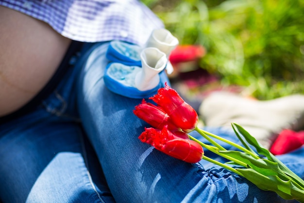 Ragazza di gravidanza e tulipani rossi