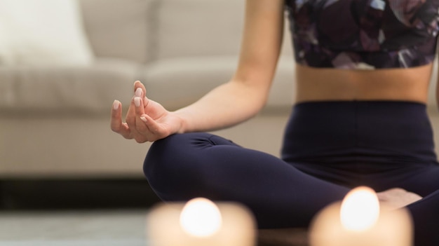 Ragazza di meditazione dell'aroma nella posizione del loto che si siede sul pavimento