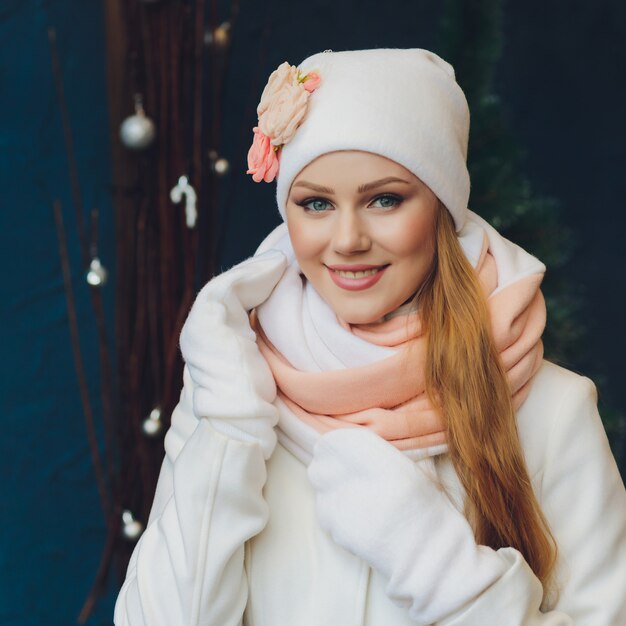 Ragazza di natale che porta cappello e guanti caldi lavorati a maglia, isolati su gray