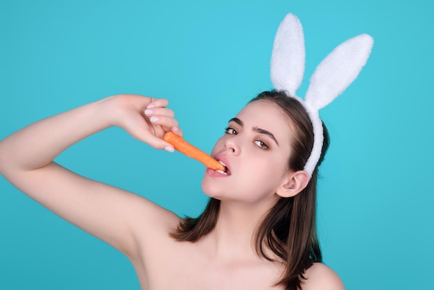 Ragazza di Pasqua giovane donna che indossa le orecchie del coniglietto di pasqua tenendo le uova colorate decorative sul backgrou dello studio