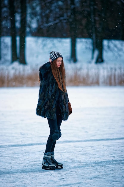 Ragazza di pattinaggio su ghiaccio presso la pista di pattinaggio invernale ricoperta di neve a Trakai in Lituania.