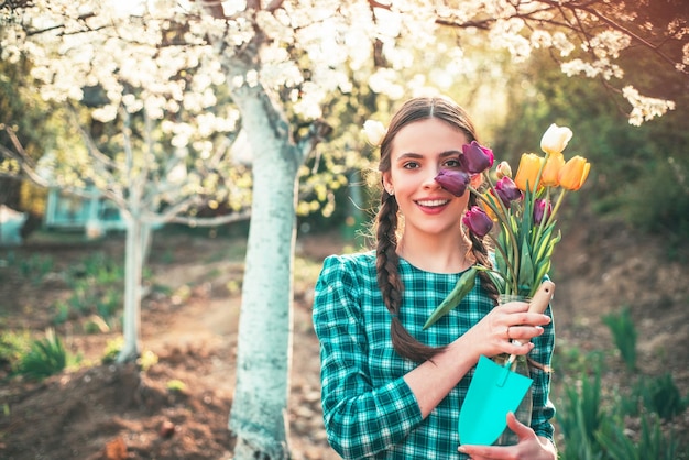 Ragazza di primavera di bellezza con il tulipano flovers giovane ragazza rilassante in giardino