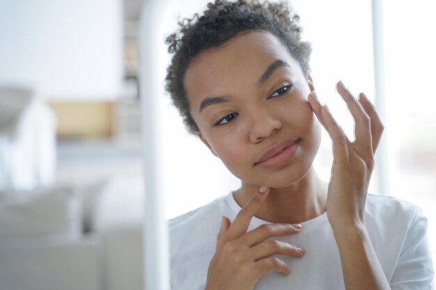 Ragazza di razza mista che fa la procedura di bellezza per la cura della pelle per una pelle sana Pubblicità di cosmetici