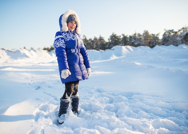 Ragazza di risata positiva in un cappotto blu di inverno