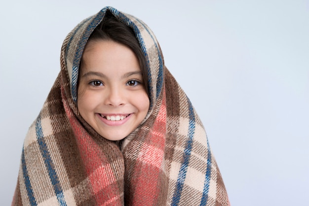 Ragazza di smiley con coperta invernale