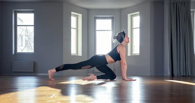 Ragazza di yoga mattutina che fa esercizi di stretching nella stanza per Pilates Belle foto di aria leggera uno stile di vita sano ormoni del corpo e illuminazione dell'anima spazio per la copia