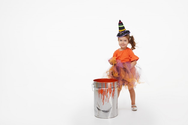 Ragazza divertente del bambino in costume della strega per Halloween su bianco