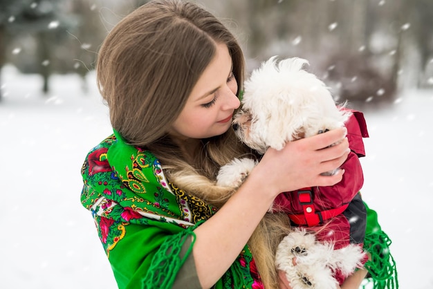 Ragazza e cagnolino insieme nel parco invernale