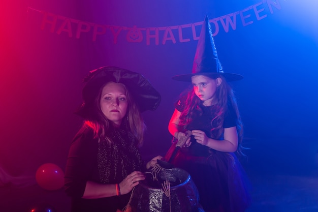 Ragazza e donna divertenti del bambino in costumi delle streghe per Halloween con la zucca Jack.