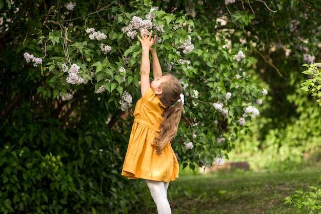 ragazza e fiori lilla in giardino in estate