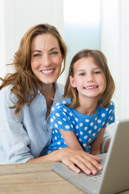 Ragazza e madre usando il portatile