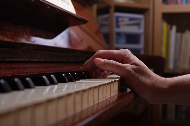 Ragazza e pianoforte a casa messa a fuoco selettiva