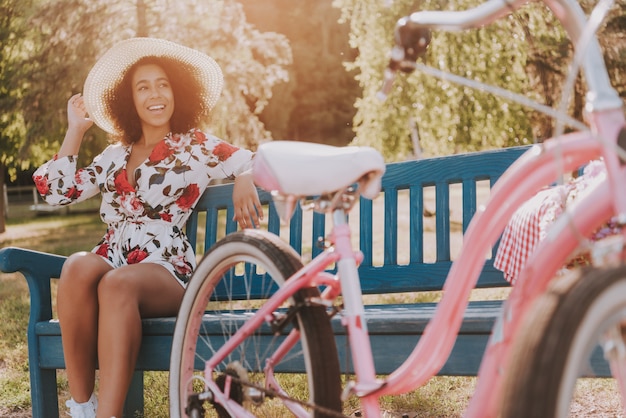 Ragazza è Seduta Sulla Panchina Accanto Alla Bicicletta.