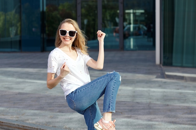 Ragazza emotiva positiva felice fuori dall'edificio in estate