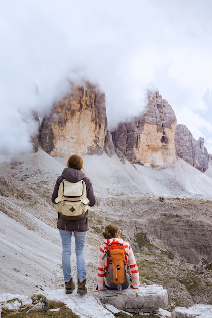 Ragazza escursionista che riposa e guarda le Tre Cime di Lavaredo. Dolomiti, Italia.