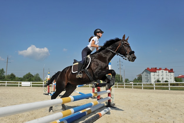 Ragazza fantino in fattoria con il suo cavallo