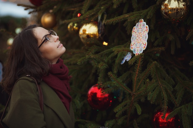 Ragazza felice allegra che gode nevicando tempo sulla via.