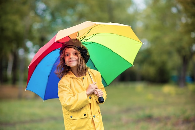 Ragazza felice bambino divertente con ombrello in stivali di gomma