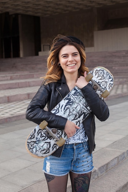 Ragazza felice che abbraccia lo skateboard