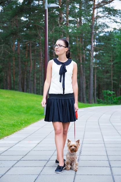 ragazza felice che cammina con il cagnolino yorkshire terrier