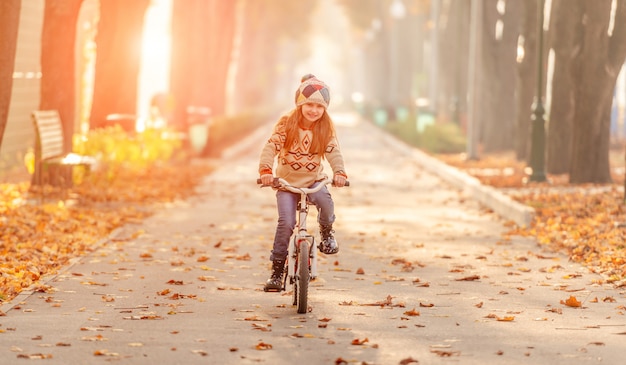 Ragazza felice che guida la bici nel parco