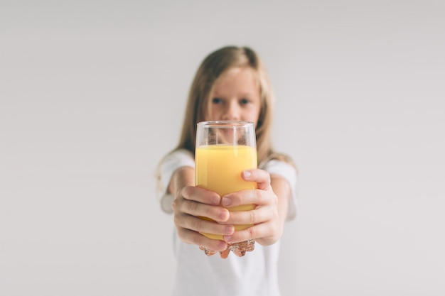 Ragazza felice che tiene vetro di succo d'arancia