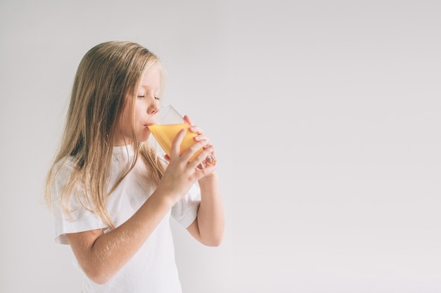 Ragazza felice che tiene vetro di succo d'arancia