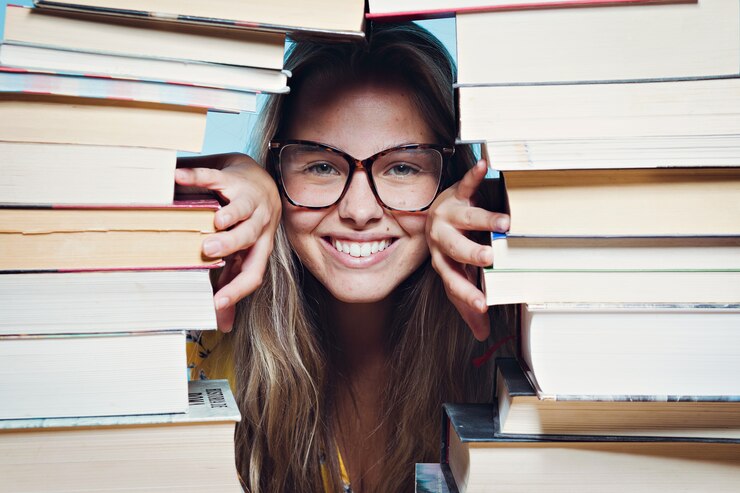 Ragazza felice circondata da libri