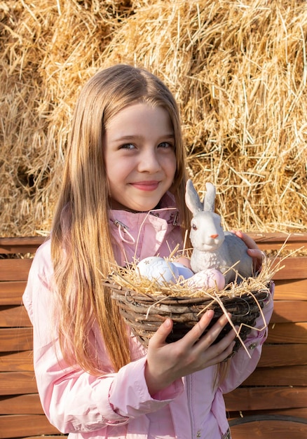 ragazza felice con coniglietto di pasqua e uova all'aperto
