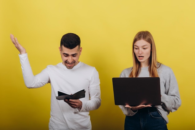 Ragazza felice con il ragazzo che guarda il laptop su sfondo giallo Studiano insieme Risolvi i problemi Concetto di lavoro di apprendimento