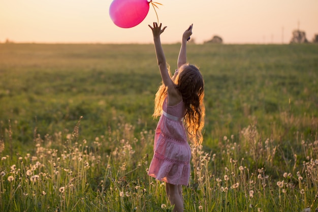 Ragazza felice con l'aerostato rosa esterno