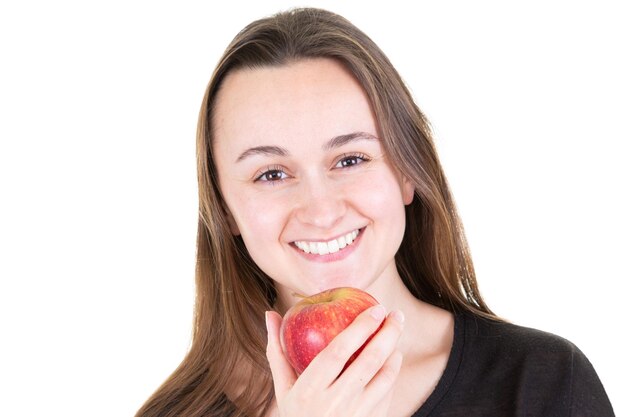 Ragazza felice con un grande sorriso che tiene in mano una mela rossa