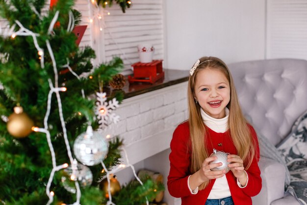 Ragazza felice con un regalo vicino all'albero di Natale