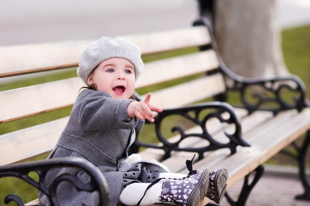 Ragazza felice del bambino di 23 anni che mostra qualcosa con il dito all'aperto Guardando avanti