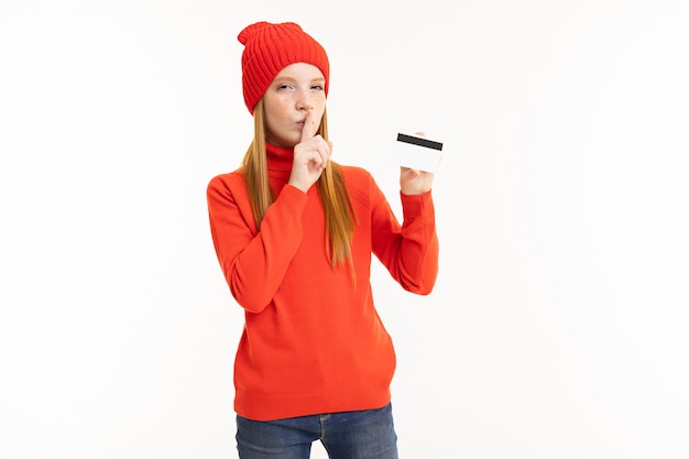 Ragazza felice dell'adolescente con capelli rossi, maglia con cappuccio rossa e cappello con la carta isolata su bianco