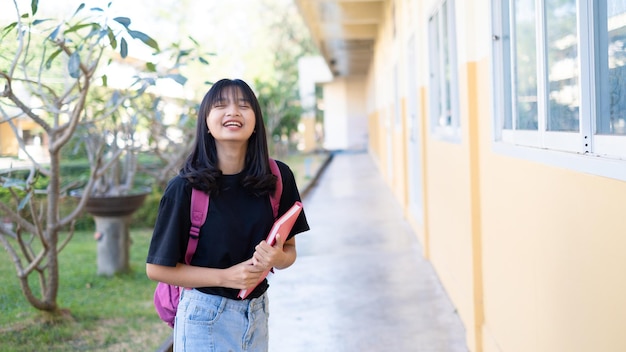 Ragazza felice dello studente con lo zaino a scuola.