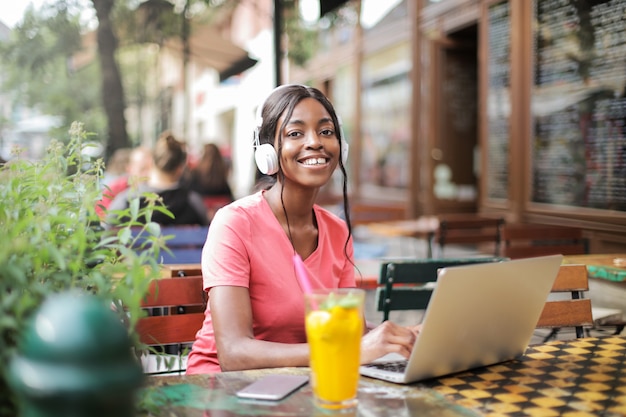 Ragazza felice di afro che si siede su un terrazzo