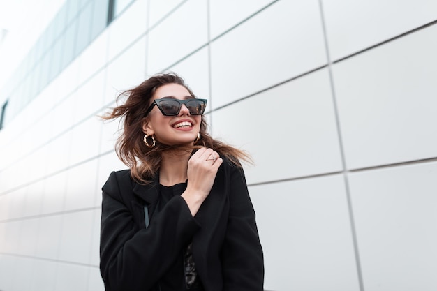 Ragazza felice di modo in vestiti neri alla moda