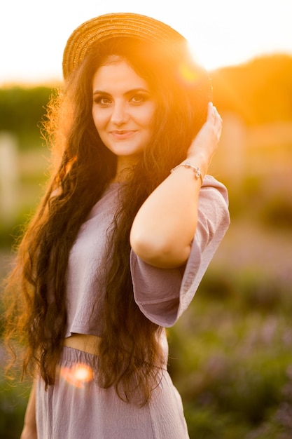 Ragazza felice e carina al tramonto in un campo di lavanda