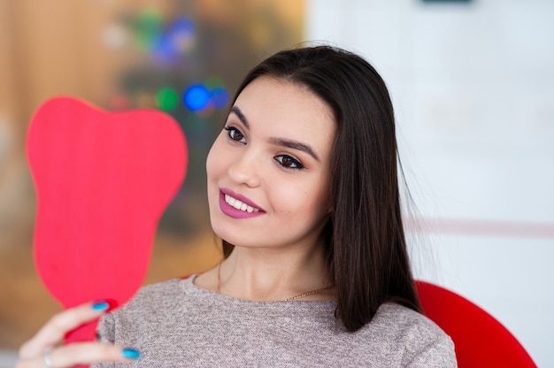 Ragazza felice guardarsi allo specchio un sorriso in odontoiatria.