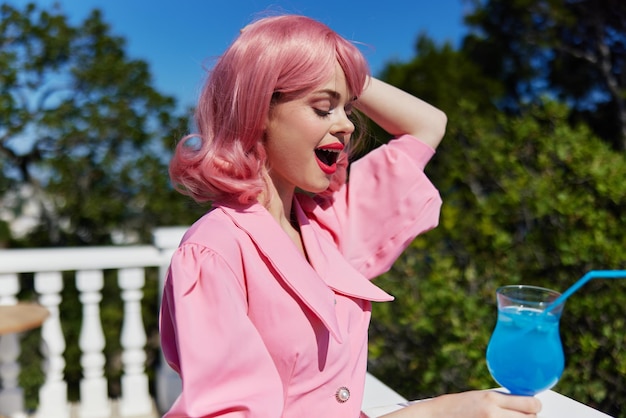Ragazza felice in abito rosa all'aperto con cocktail donna felice rilassante foto di alta qualità